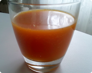 Sea Buckthorn Water Kefir Orange colored, thick sea buckthorn water kefir soda in a glass