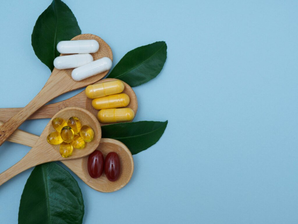 probiotic supplements in capsules on wooden spoons